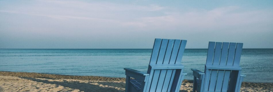 two blue beach chairs near body of water