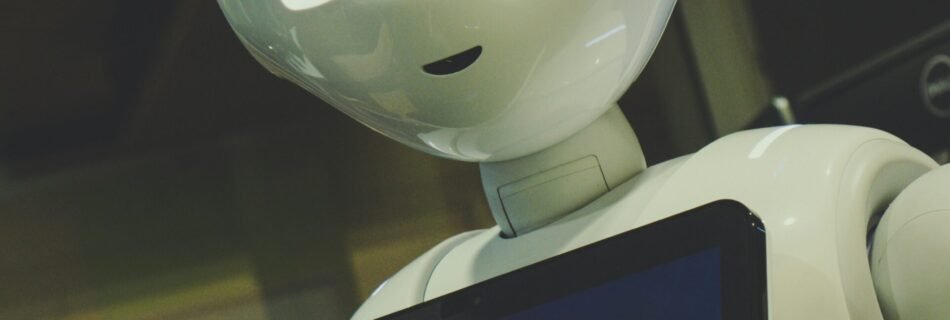 white robot toy holding black tablet