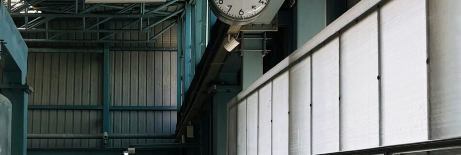 a clock hanging from the ceiling of a building